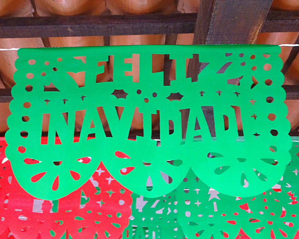 Green paper cutout with 'Feliz Navidad' text on a wooden surface