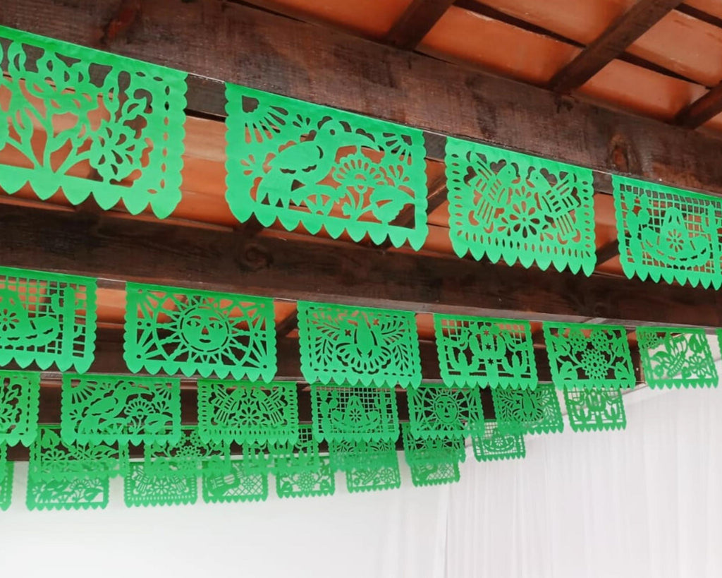 Green paper cutout decorations hanging from a wooden ceiling