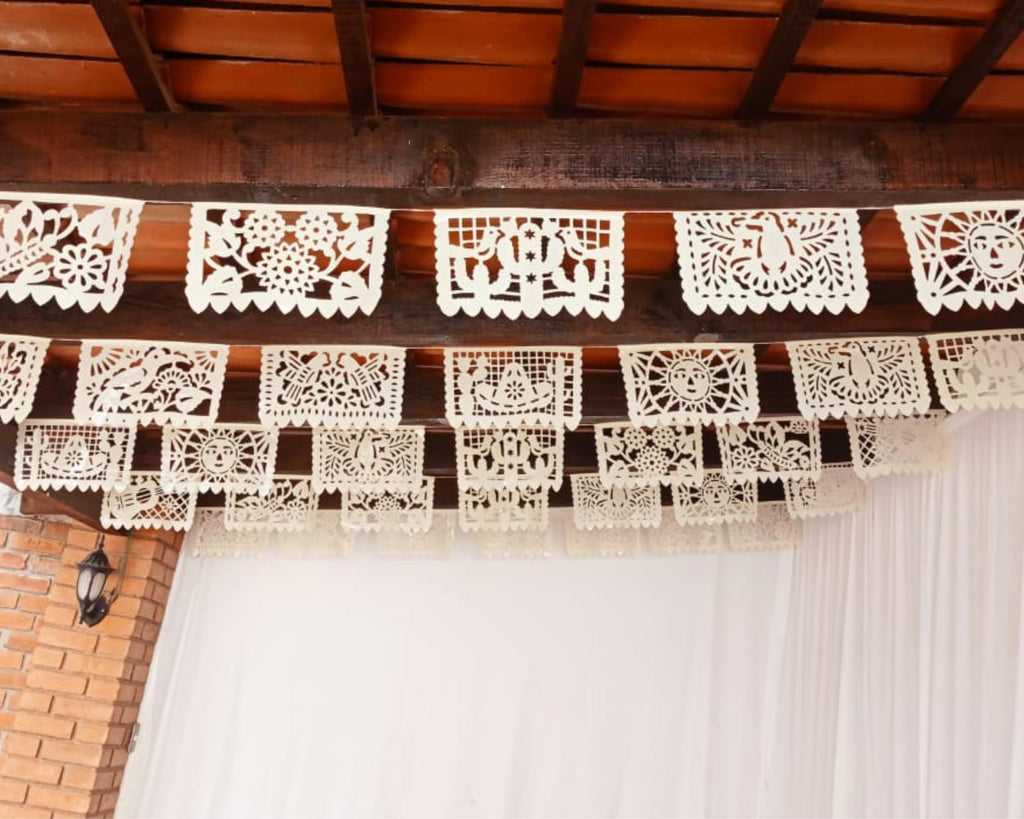 Decorative white paper cutouts hanging from a wooden ceiling