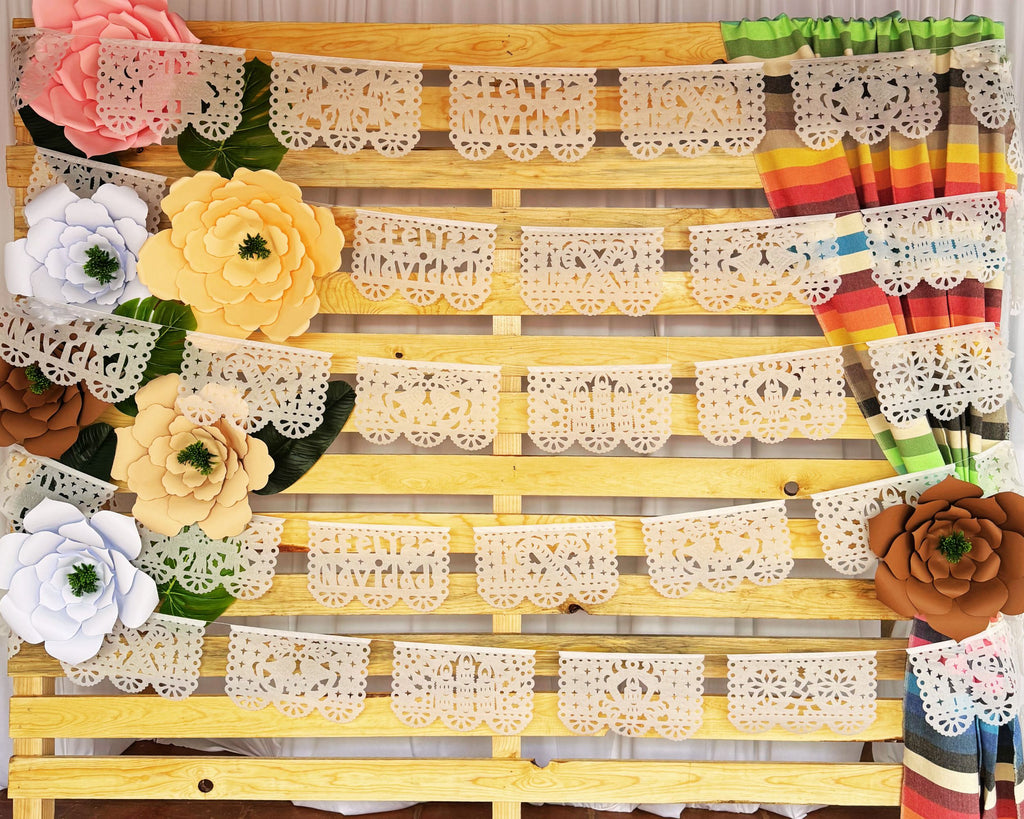 A white Christmas Papel Picado banner with intricate lace designs, pre-strung and ready to hang, displayed alongside other decorative items.