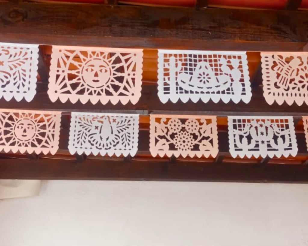 Decorative paper cutout banners with intricate patterns on a wooden surface.