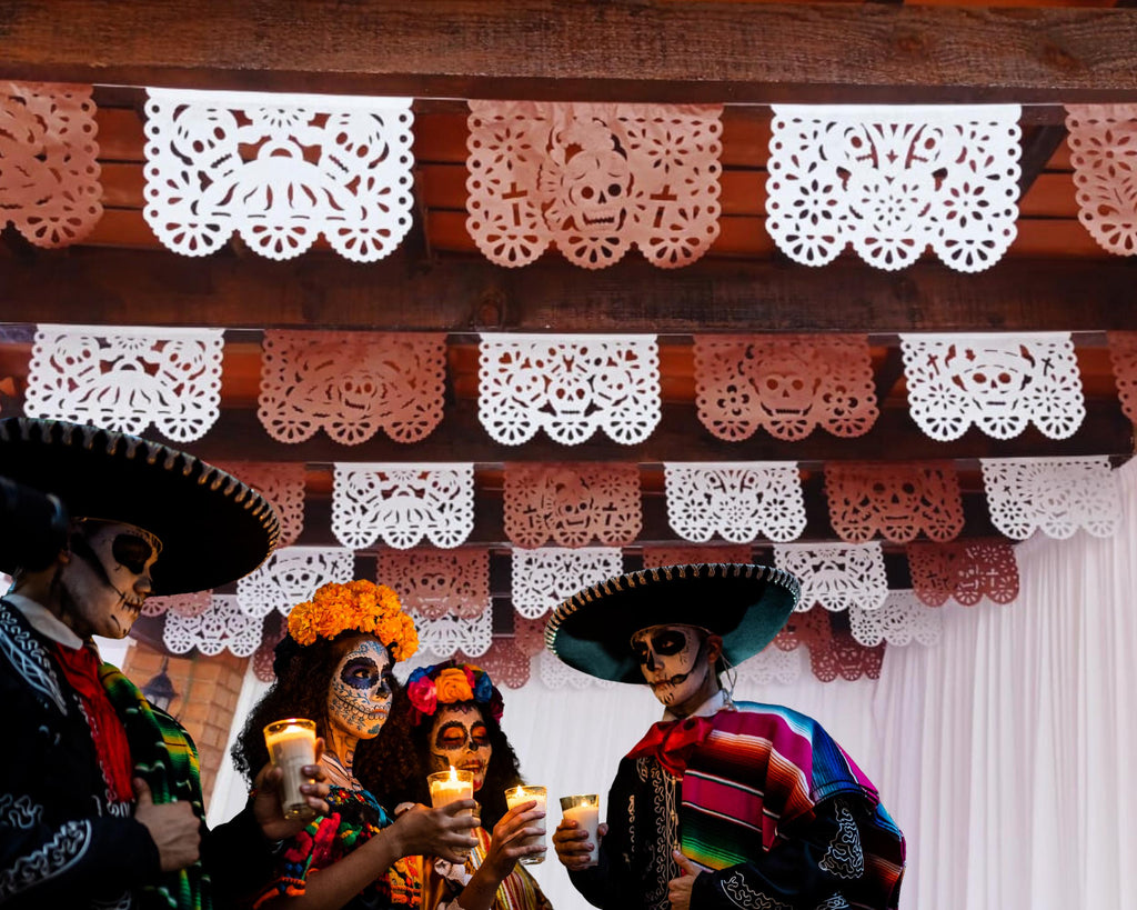 Decorative setup with skeleton figures and papel picado, likely for Day of the Dead celebration.