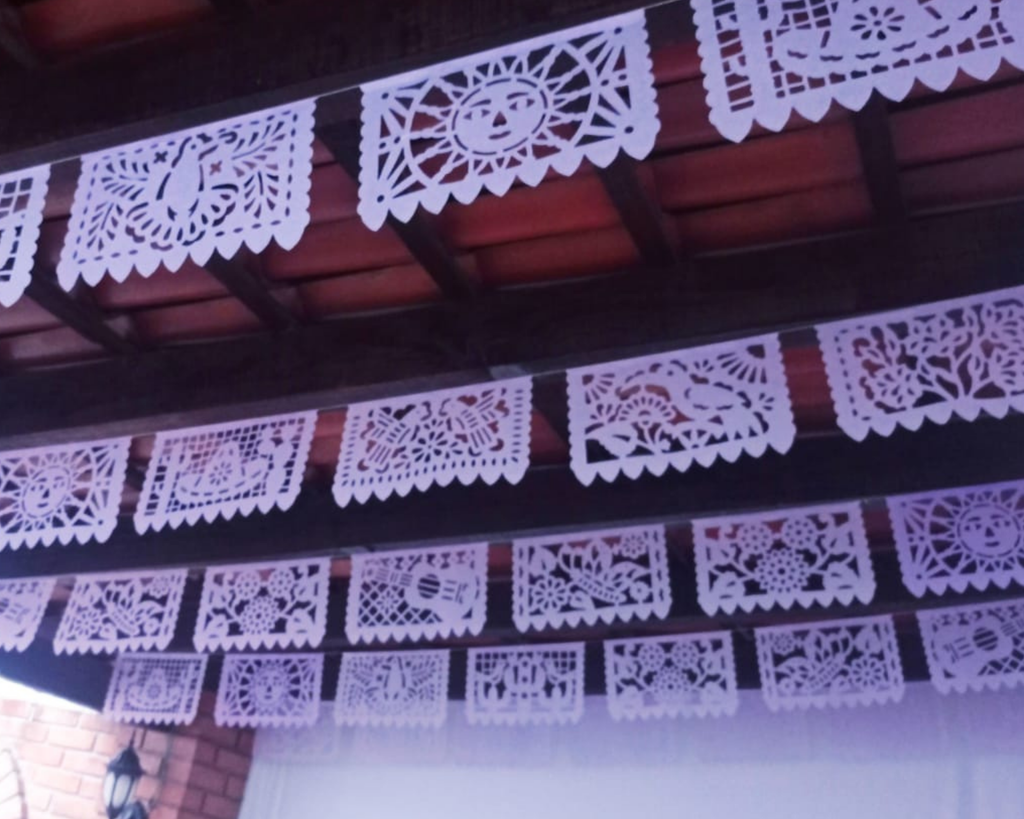 Decorative light purple paper cutouts hanging from a wooden ceiling