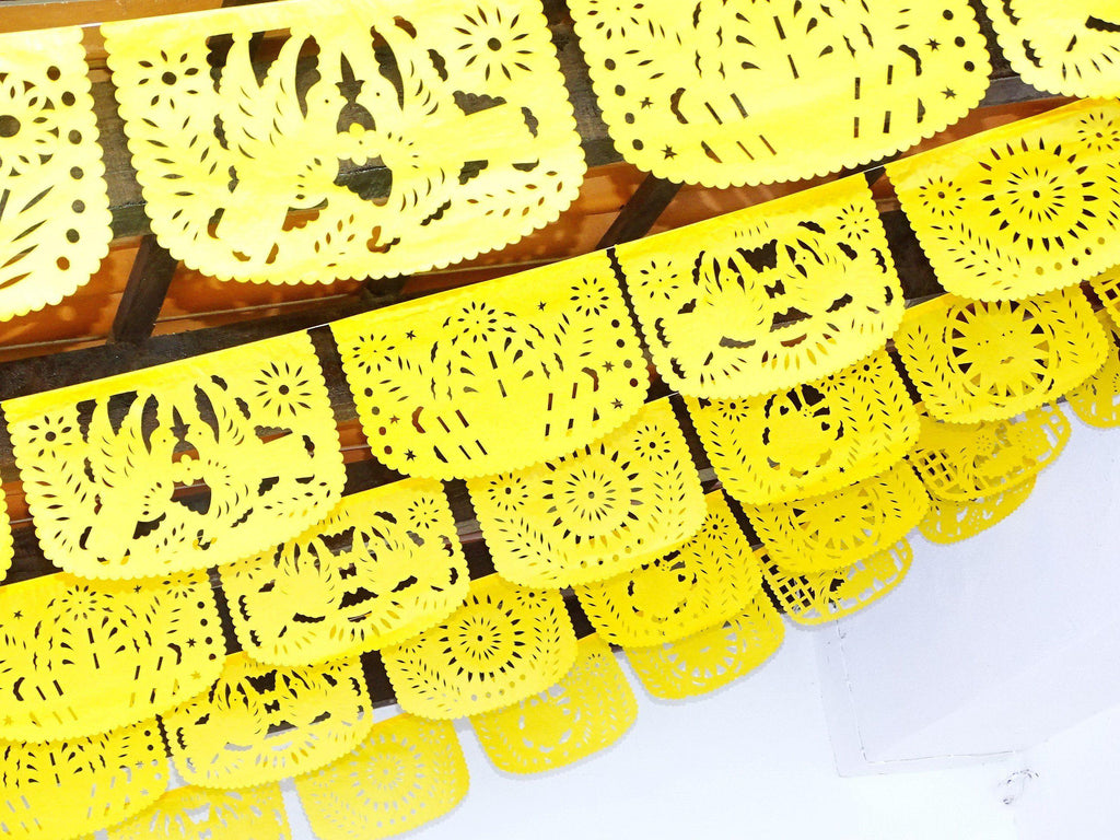 Bright yellow papel picado with spring design, banner for Mexican themed parties, fiesta backdrop.